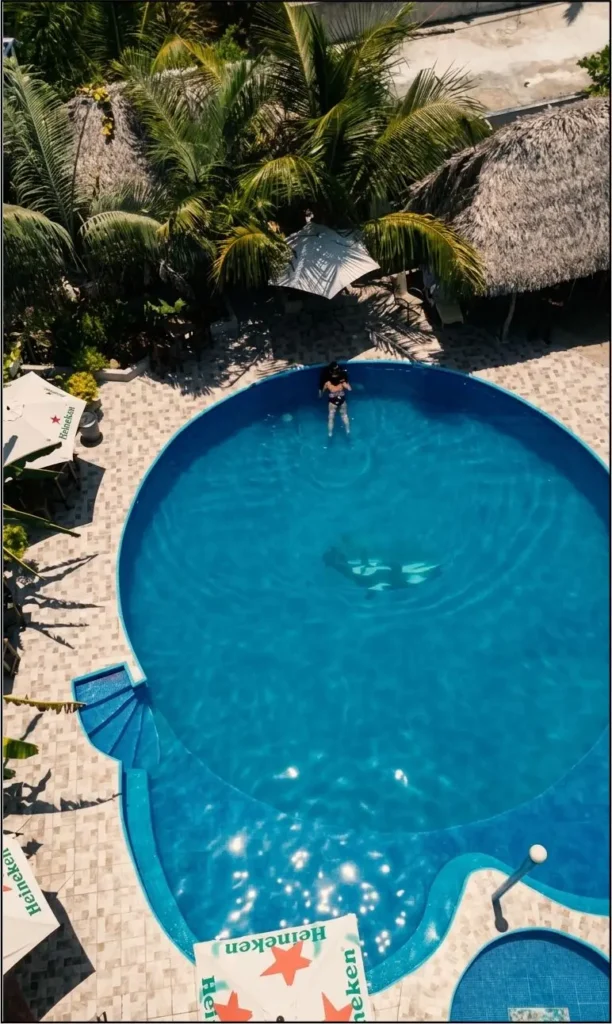 Vista aérea de la alberca al aire libre y áreas de descanso rodeadas de palmeras en el Hotel Punta Cana en Tecolutla.