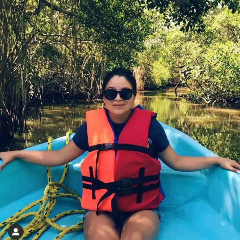 Turista con chaleco salvavidas disfrutando de un paseo en lancha por los manglares de Tecolutla, Veracruz, una actividad ecoturística clave que visitar en la región.
